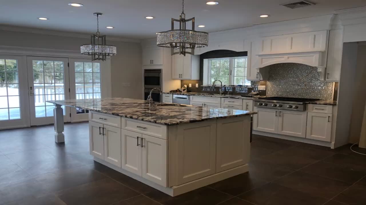 Finished kitchen with white shaker cabinets, granite island and double wall ovens