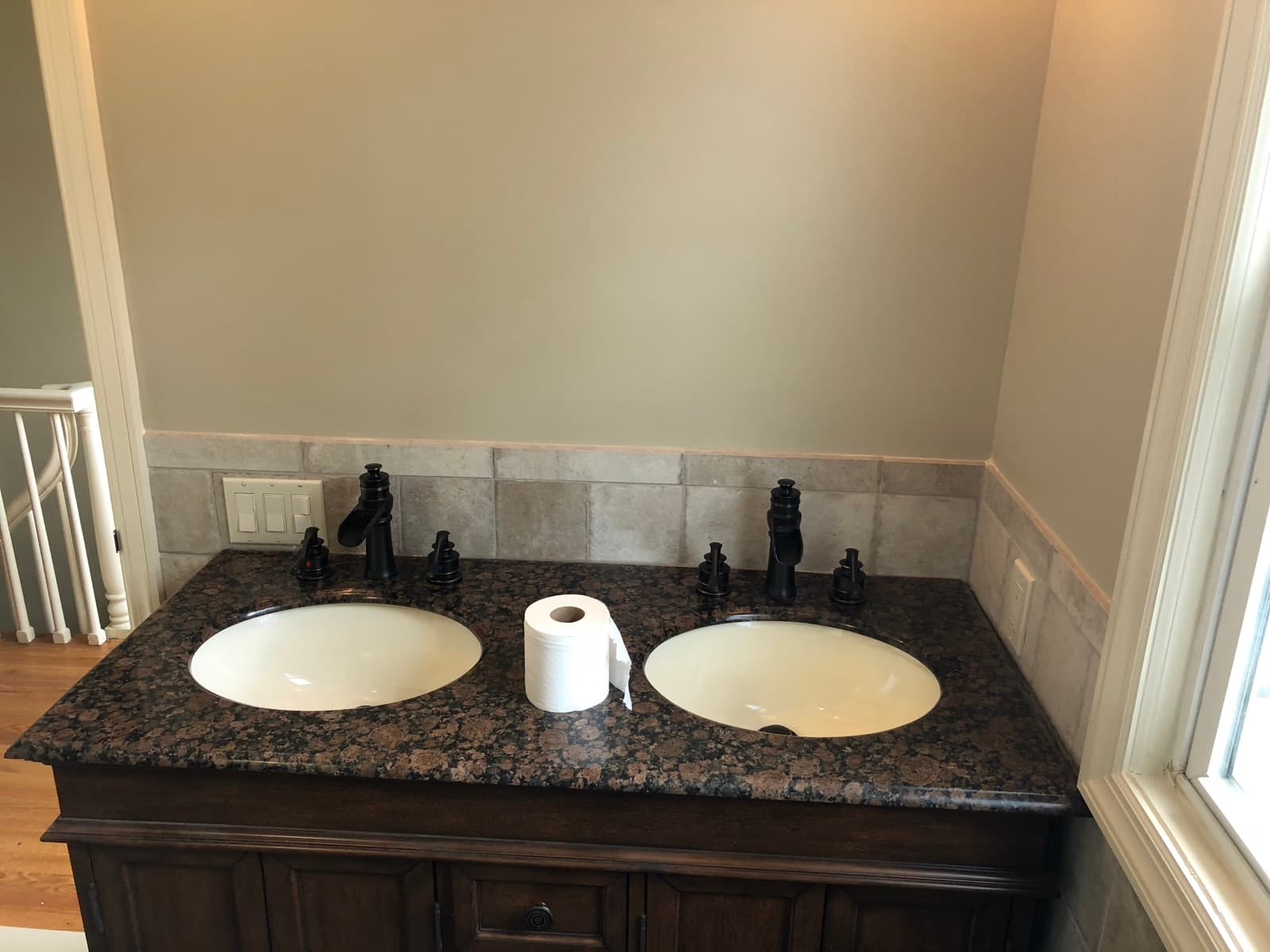 Double vanity with a stone top, two undermount sinks and bronze fixtures