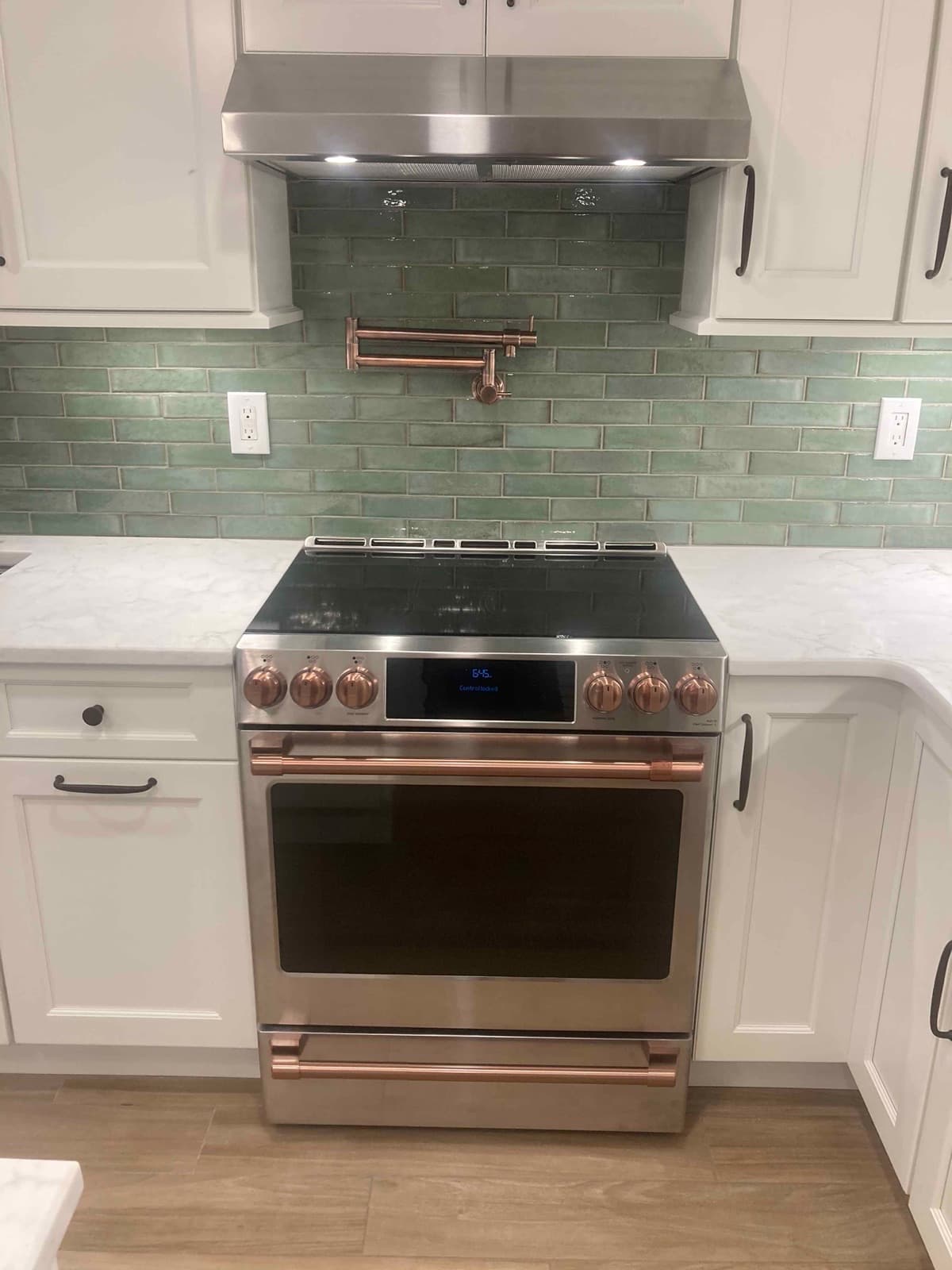 Range wall with stainless hood and a pot filler over the cooktop